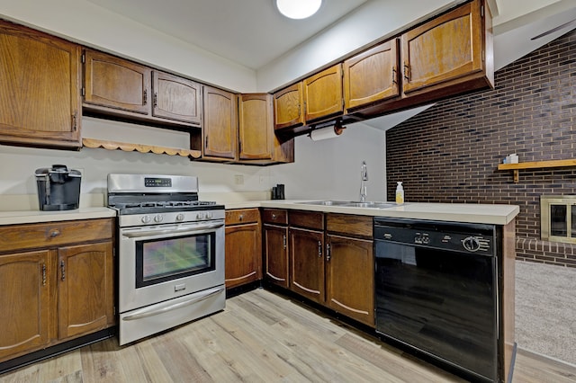 kitchen featuring gas stove, sink, dishwasher, and light hardwood / wood-style flooring