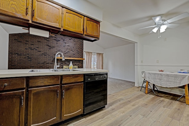 kitchen featuring sink, vaulted ceiling, ceiling fan, light wood-type flooring, and black dishwasher