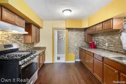 kitchen with decorative backsplash, dark hardwood / wood-style flooring, sink, and stainless steel range with gas stovetop