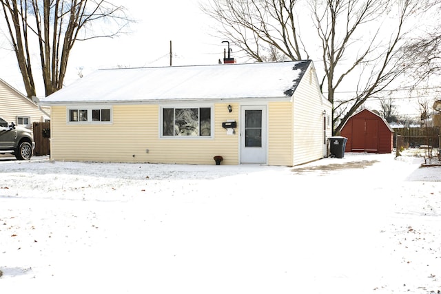 view of front of property featuring a storage shed