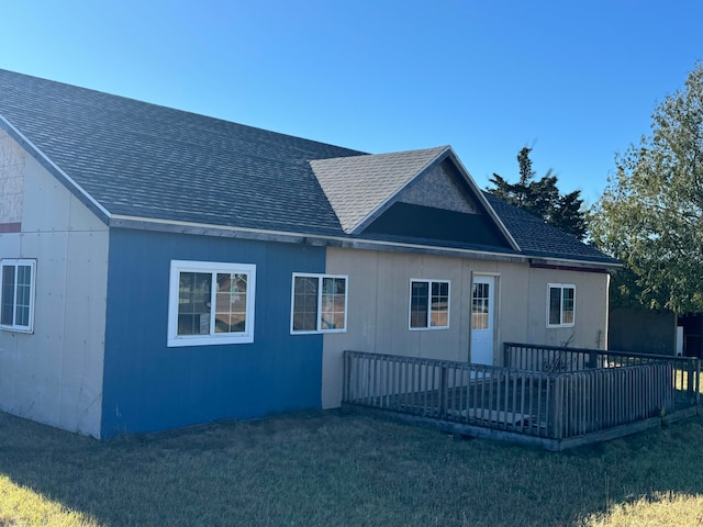 back of property featuring a lawn and a deck