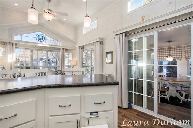 kitchen featuring lofted ceiling, hanging light fixtures, dark hardwood / wood-style floors, ceiling fan, and white cabinetry