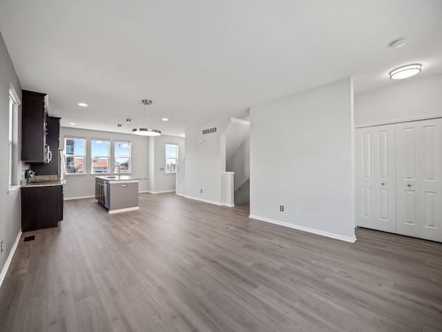 unfurnished living room with hardwood / wood-style flooring and sink