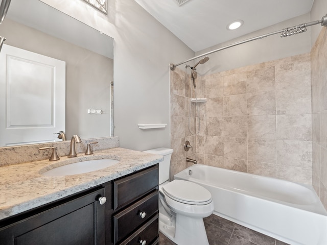 full bathroom with tile patterned flooring, vanity, tiled shower / bath combo, and toilet