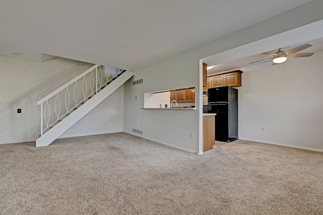 2765 Fox Hollow Ct, Lake Orion, MI 48360 - unfurnished living room featuring stairway, light carpet, ceiling fan, baseboards, and a sink