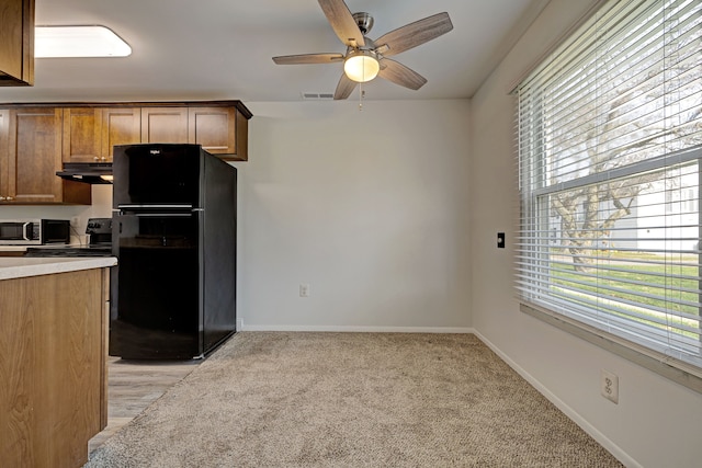 2765 Fox Hollow Ct, Lake Orion, MI 48360 - kitchen with freestanding refrigerator, stainless steel microwave, a ceiling fan, and plenty of natural light