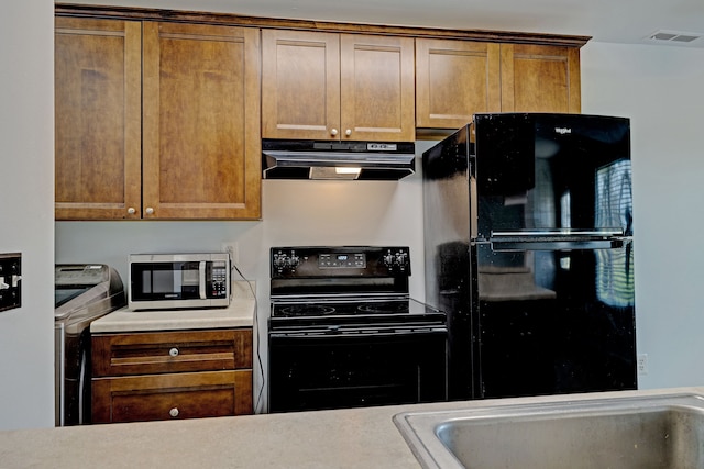 2765 Fox Hollow Ct, Lake Orion, MI 48360 - kitchen featuring under cabinet range hood, black appliances, light countertops, and brown cabinetry