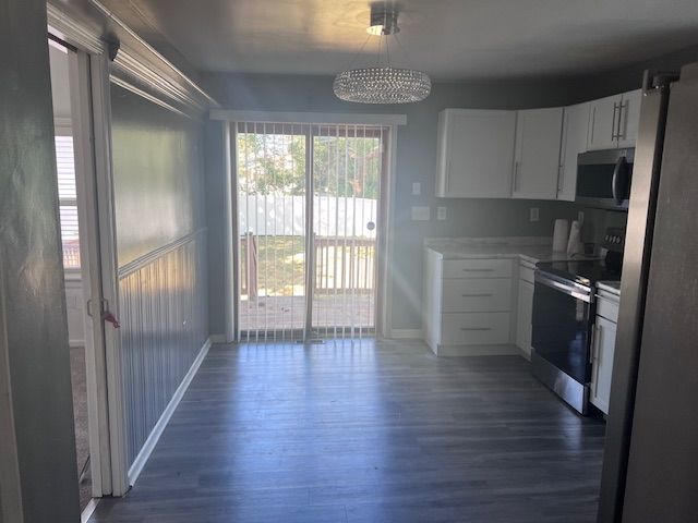 kitchen with white cabinets, dark hardwood / wood-style flooring, and stainless steel appliances