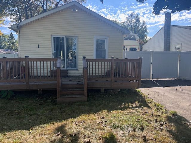 back of house featuring a yard and a wooden deck