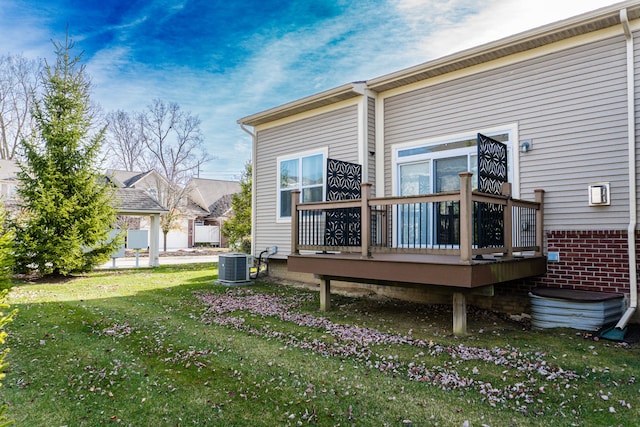 rear view of house featuring a wooden deck, cooling unit, and a yard