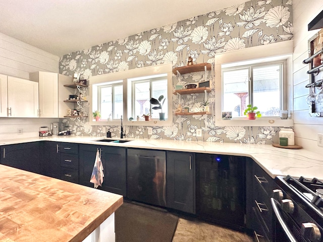 kitchen featuring butcher block countertops, plenty of natural light, white cabinetry, and sink