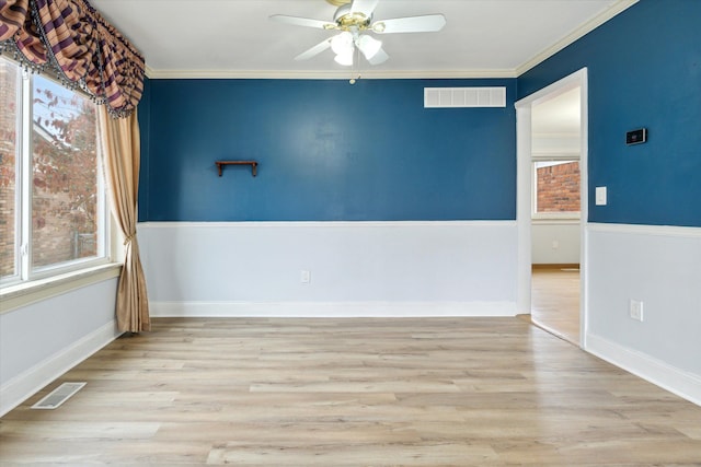 unfurnished room featuring light hardwood / wood-style flooring, a wealth of natural light, crown molding, and ceiling fan