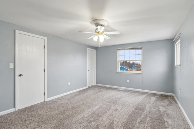 carpeted spare room featuring ceiling fan