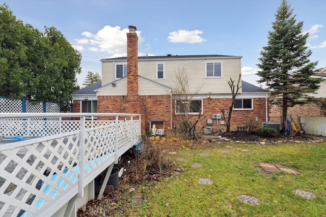 back of house with a deck and a lawn