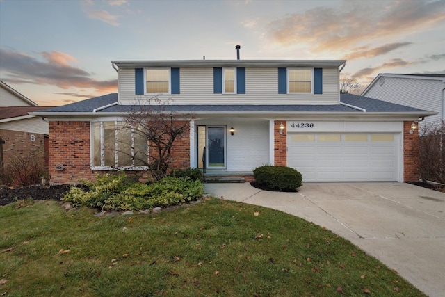 view of property with a lawn and a garage