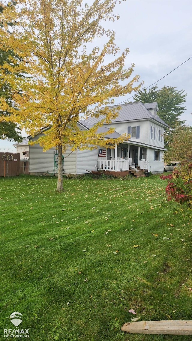 back of property with a yard and a porch