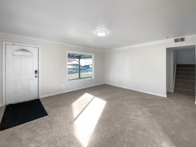 carpeted foyer featuring ornamental molding