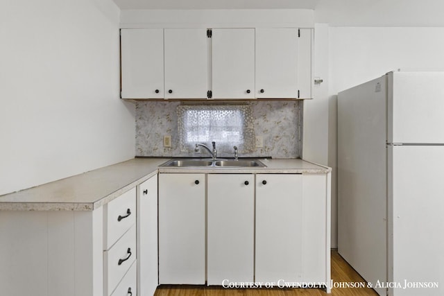 100 Inca Dr SW, Grand Rapids, MI 49548 - kitchen featuring freestanding refrigerator, a sink, light countertops, and white cabinets