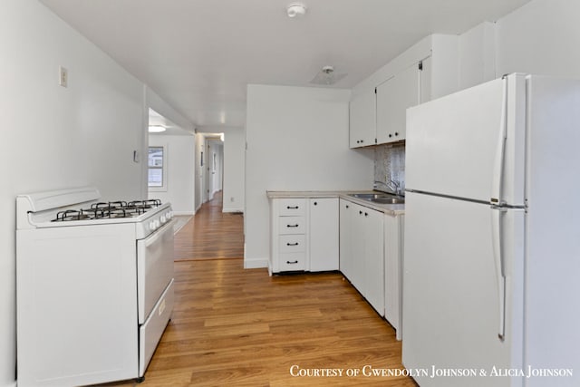 kitchen featuring white cabinetry, sink, tasteful backsplash, light hardwood / wood-style flooring, and white appliances