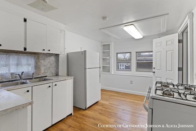 100 Inca Dr SW, Grand Rapids, MI 49548 - kitchen with white appliances, a sink, light countertops, white cabinetry, and decorative backsplash