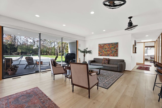 living room with ceiling fan and light hardwood / wood-style floors