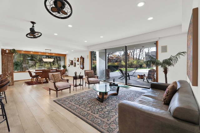 living room featuring ceiling fan and light hardwood / wood-style flooring