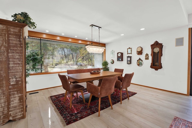 dining room featuring light hardwood / wood-style floors and a chandelier