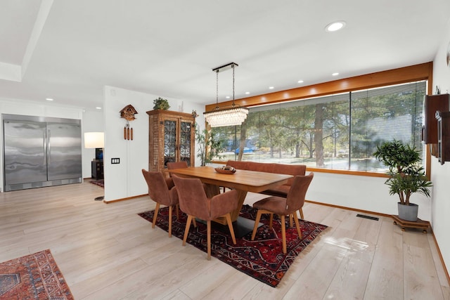 dining room featuring an inviting chandelier and light wood-type flooring