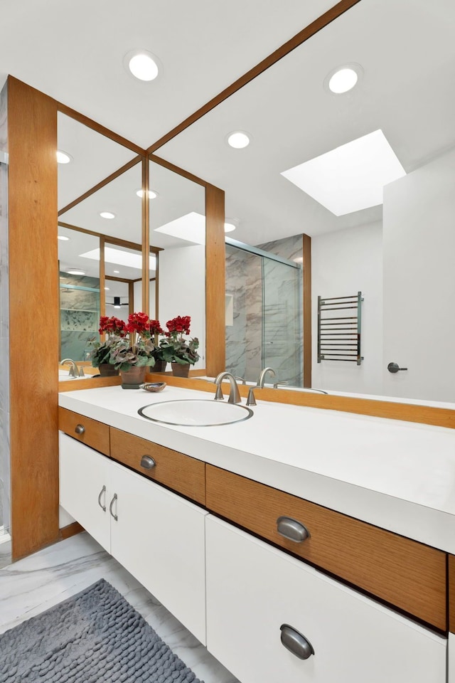 bathroom featuring a skylight, vanity, and walk in shower