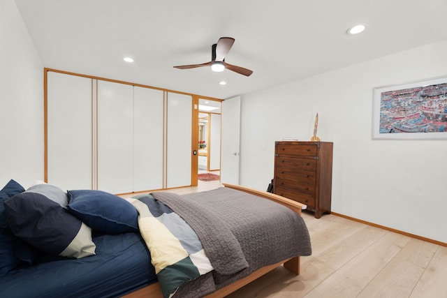 bedroom with ceiling fan, a closet, and light hardwood / wood-style flooring