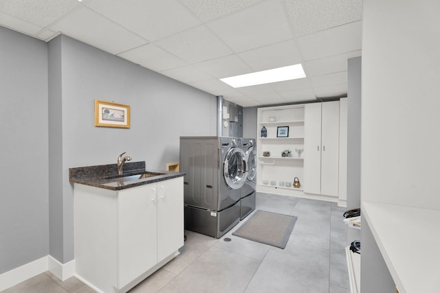 laundry area featuring cabinets, separate washer and dryer, sink, and light tile patterned floors