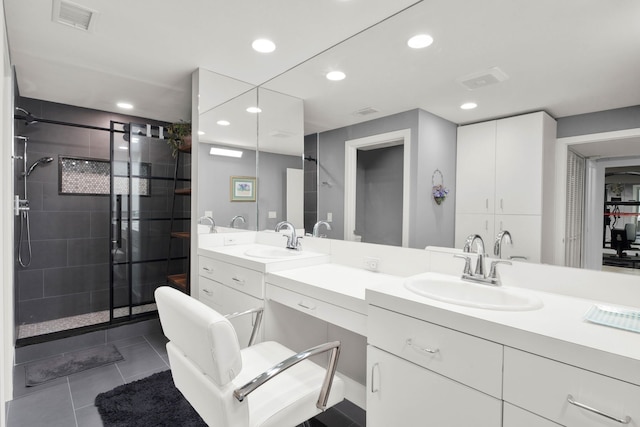 bathroom featuring a tile shower, tile patterned flooring, and vanity