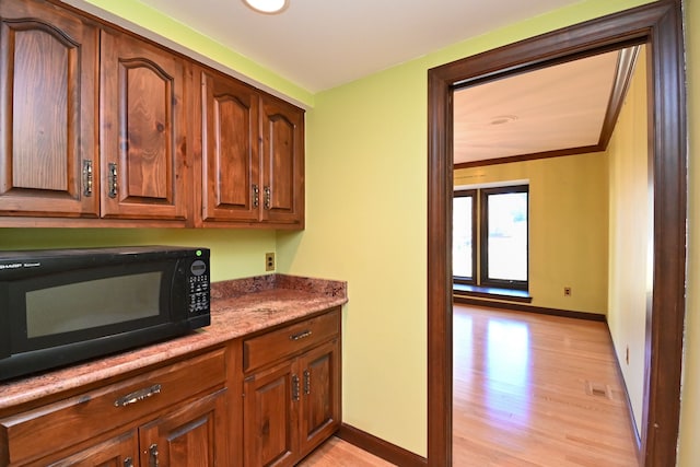 kitchen featuring visible vents, baseboards, black microwave, and light wood finished floors