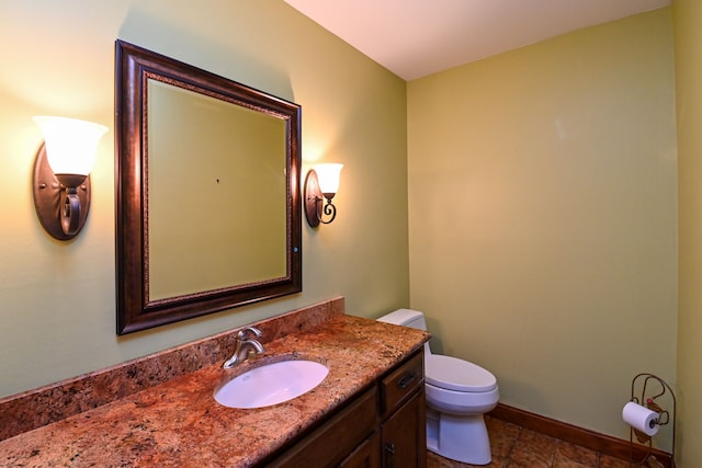 bathroom featuring toilet, baseboards, and vanity