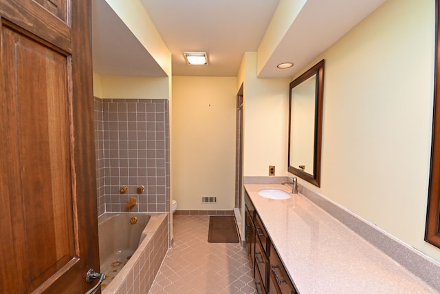 full bathroom featuring vanity, tiled shower / bath, tile patterned floors, and toilet