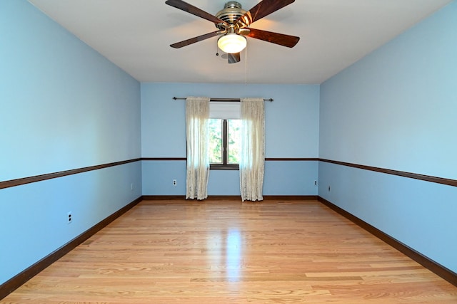 spare room featuring a ceiling fan, baseboards, and light wood-type flooring