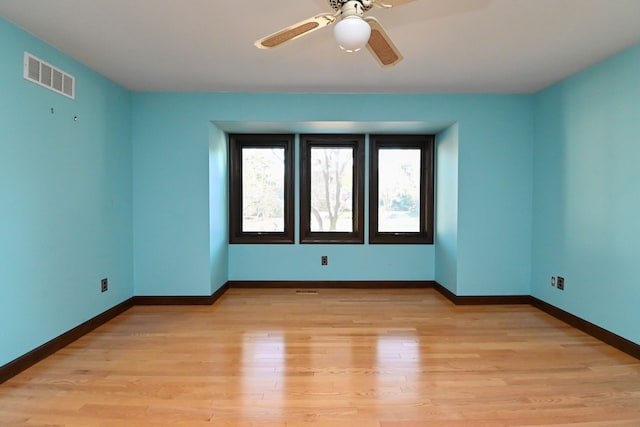 empty room with ceiling fan and light hardwood / wood-style floors