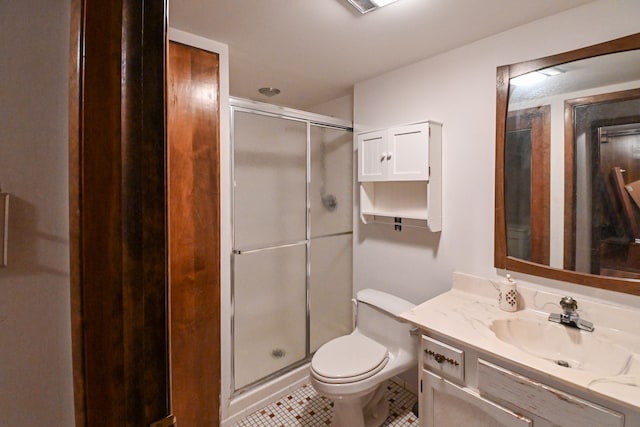 bathroom with vanity, tile patterned floors, a stall shower, and toilet