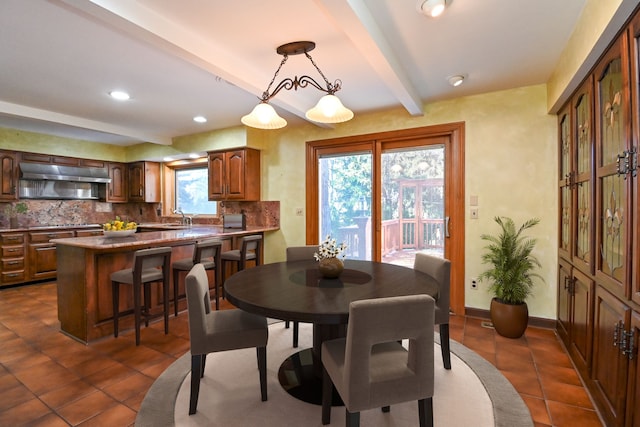 dining area with dark tile patterned floors, baseboards, recessed lighting, and beam ceiling