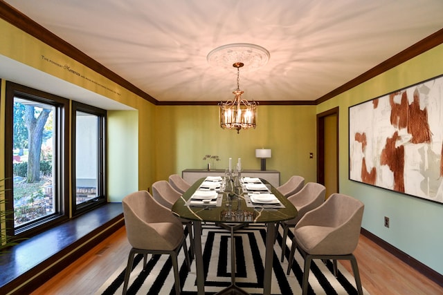 dining space with crown molding, hardwood / wood-style floors, and a chandelier