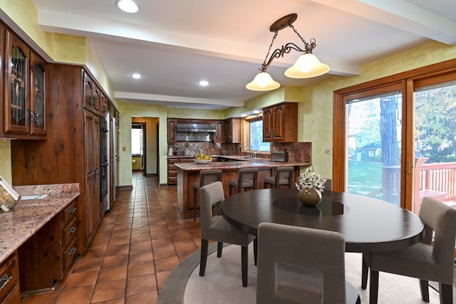 tiled dining area with beamed ceiling and sink