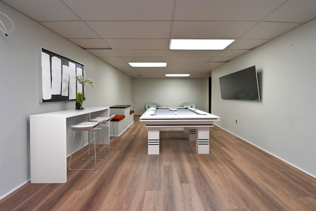 recreation room with baseboards, wood finished floors, and a paneled ceiling