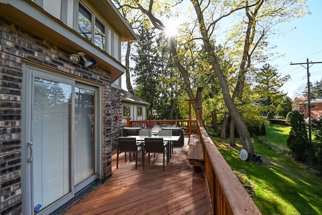 wooden deck with a lawn and outdoor dining area