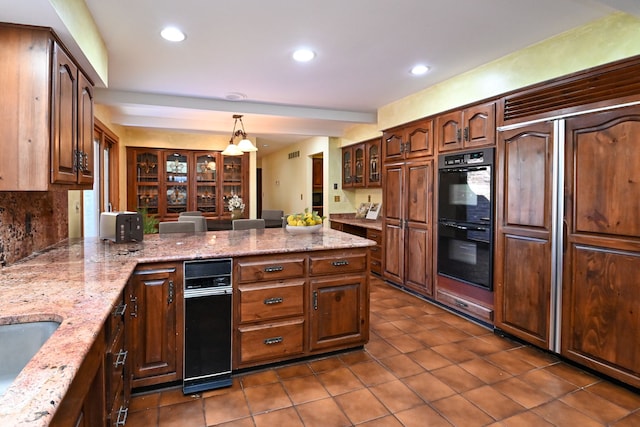 kitchen featuring double oven, hanging light fixtures, dark tile patterned floors, light stone countertops, and paneled refrigerator