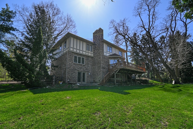 back of property with a deck, french doors, a chimney, a yard, and stairway