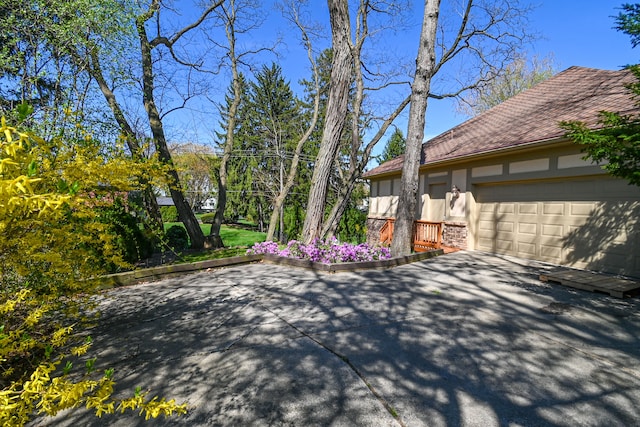 view of property exterior featuring an attached garage and aphalt driveway