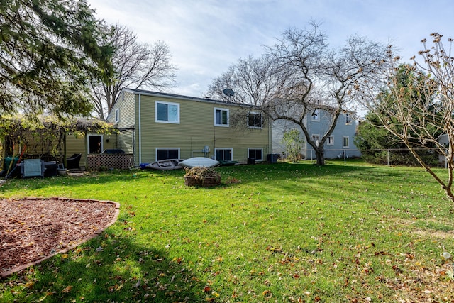 rear view of property featuring central AC and a yard