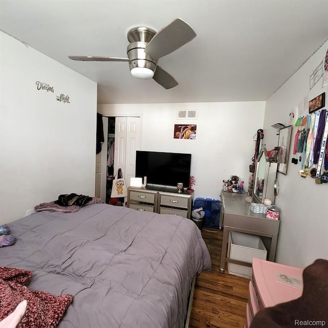 bedroom featuring hardwood / wood-style flooring, ceiling fan, and a closet