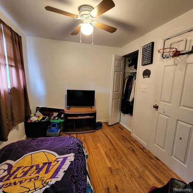 bedroom with a closet, light hardwood / wood-style floors, and ceiling fan