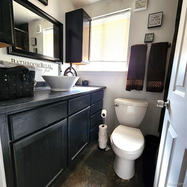 bathroom featuring vanity, toilet, and backsplash